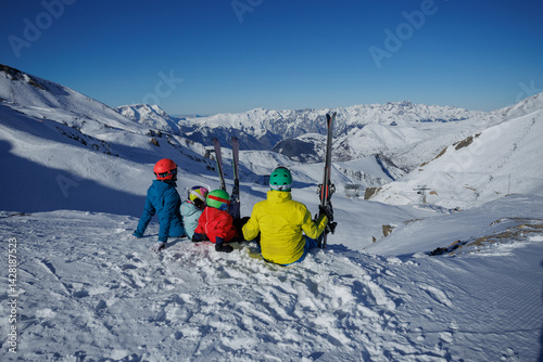 Obraz na płótnie Family of four sit on the edge in breathtaking Alpine mountains w salonie