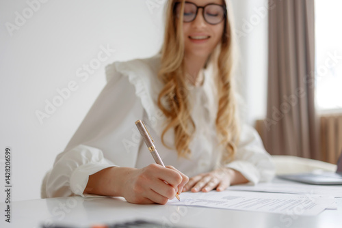 Obraz na płótnie Young woman writing notes at a bright workspace with natural light during the day w salonie