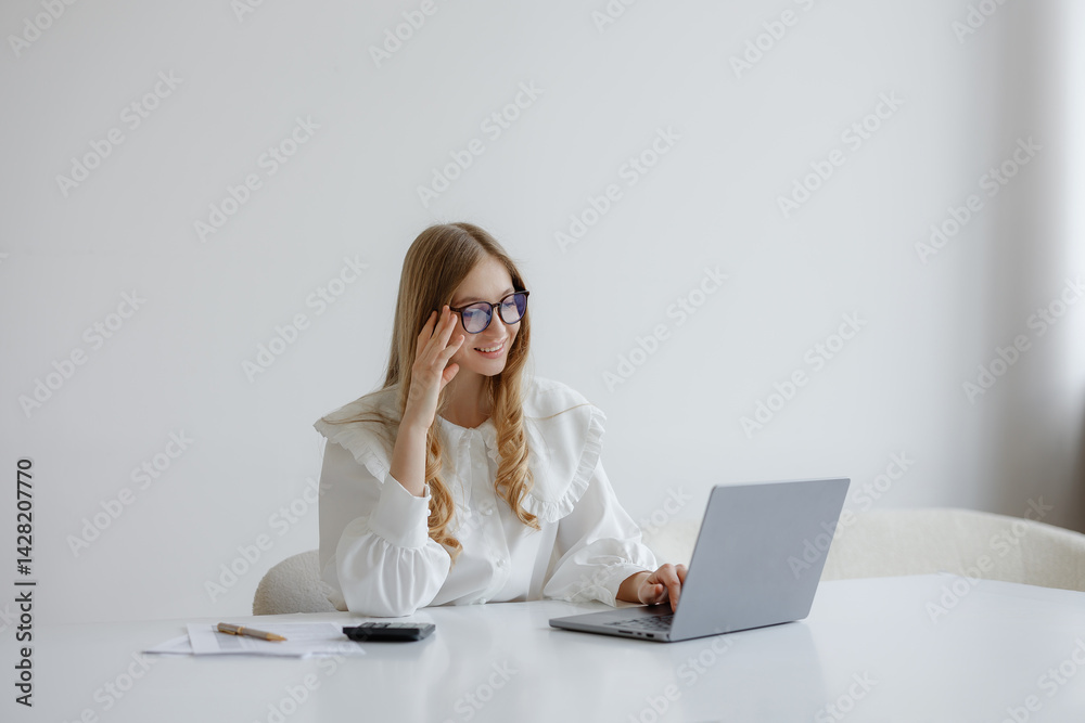 Young woman working on laptop in modern office with minimalistic design