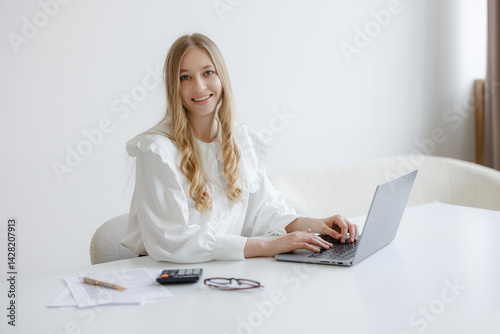 Obraz na płótnie Professional woman working on laptop in bright office setting during daylight hours w salonie