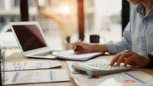 Close up of business analyst calculating financial data at desk