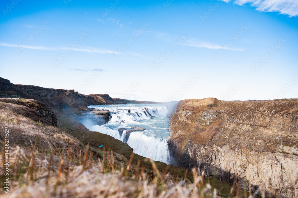 Gullfoss waterfall in Iceland rushes with immense power, carving the canyon walls as icy waters plunge into the depths below.
