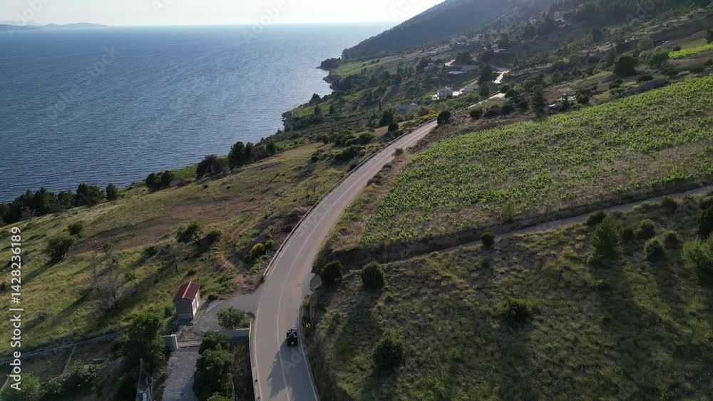 A person ATVing on long track on a lush hillside by the sea on Island of Bol in Croatia A person ATVing on long track on a lush hillside by the sea on Island of Bol in Croatia