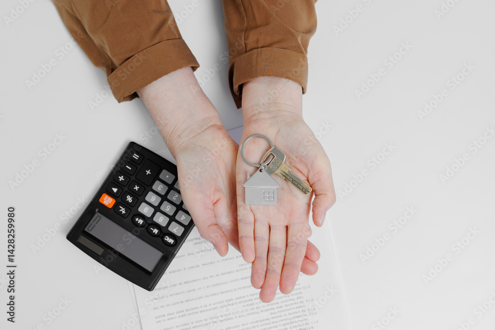 Keys and calculator on a table with documents during a property purchasing process
