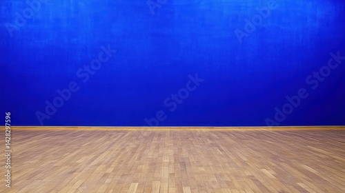 A simple wooden floor against a vibrant blue wall, creating a minimalist aesthetic.