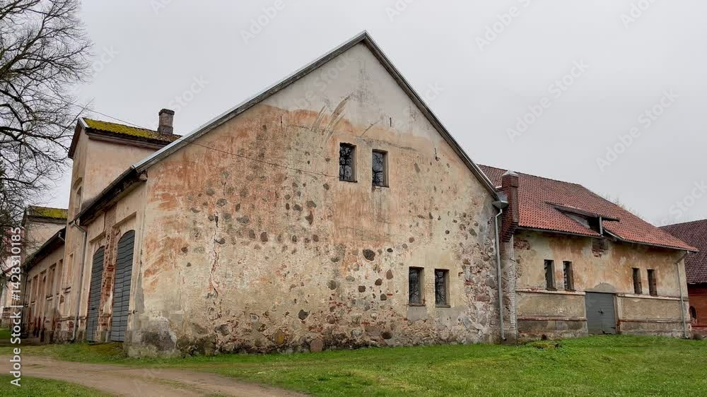 Weathered Stone and Plaster Wall of Historic Barn in Pope Manor on a Rainy Spring Day in Courland, Latvia Weathered Stone and Plaster Wall of Historic Barn in Pope Manor on a Rainy Spring Day in Courland, Latvia