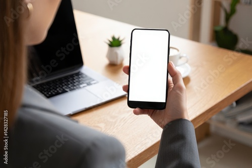 Closeup businesswoman using smartphone at office desk. Blank screen for advertising