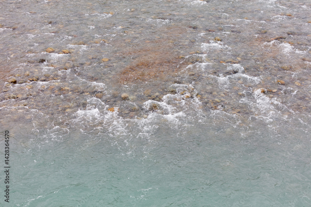 Obraz premium The water is clear and the rocks are scattered throughout the area