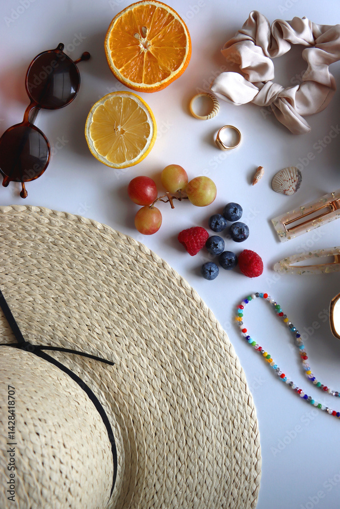 Straw hat, sunglasses, seasonal fruit, seashells and colorful accessories on white backgrounds. Cute summer essentials. Flat lay.