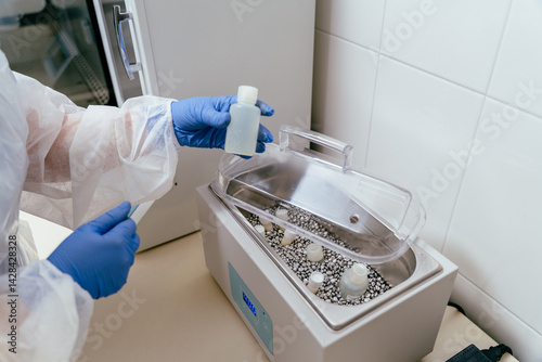 Donor milk bottle placed into warming equipment photo