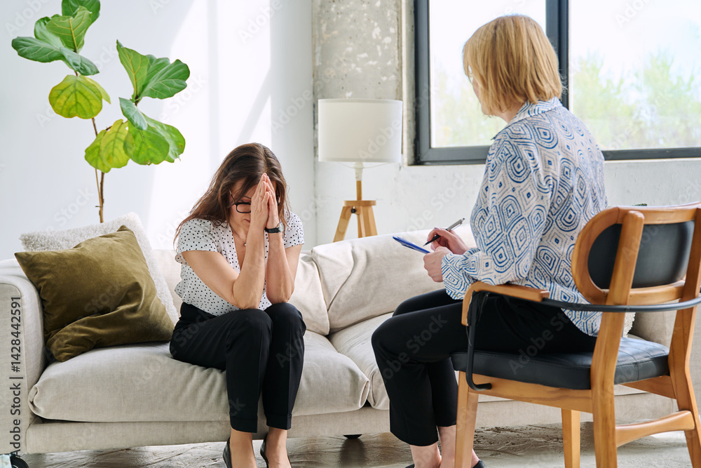 Unhappy sad middle aged woman in therapy session in psychologist therapist office