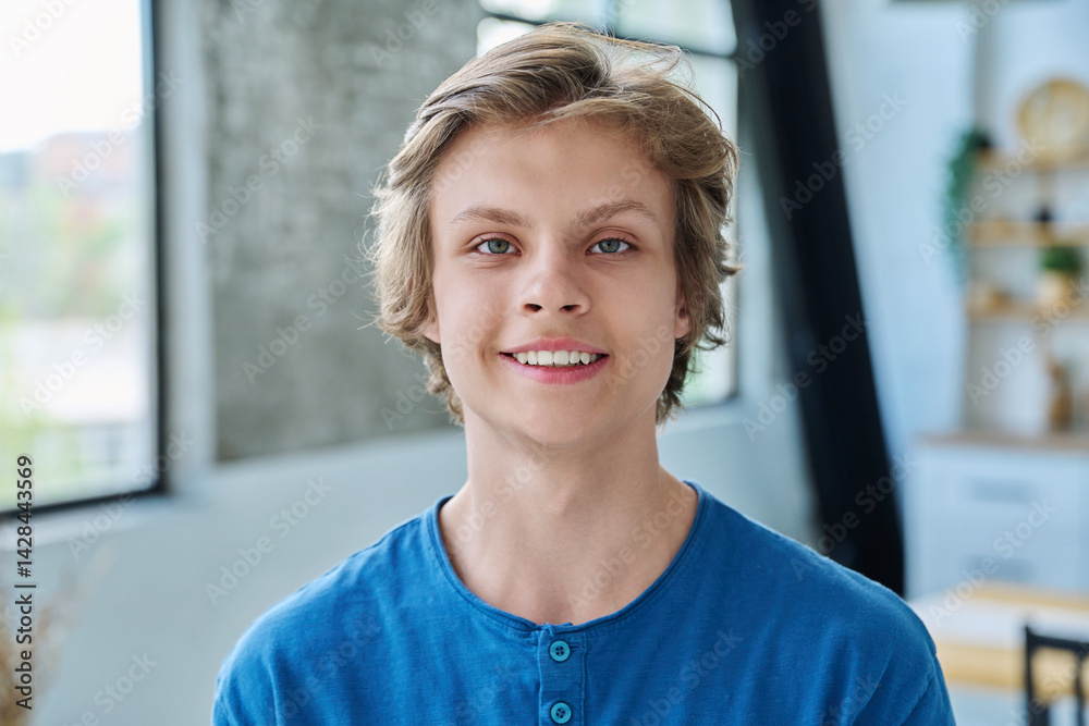 Headshot portrait of smiling teenage boy looking at camera