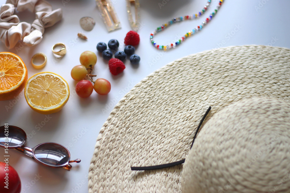 Straw hat, sunglasses, seasonal fruit, seashells and colorful accessories on white backgrounds. Cute summer essentials. Selective focus.