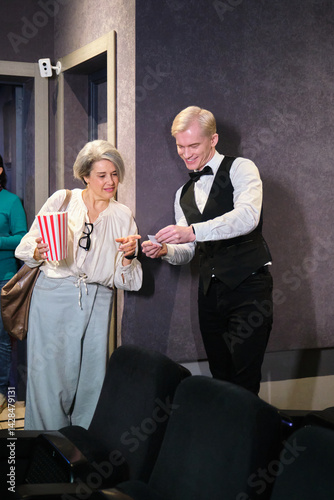 Obraz na płótnie Usher tearing ticket of a woman with popcorn bucket at the entrance to a movie theater w salonie