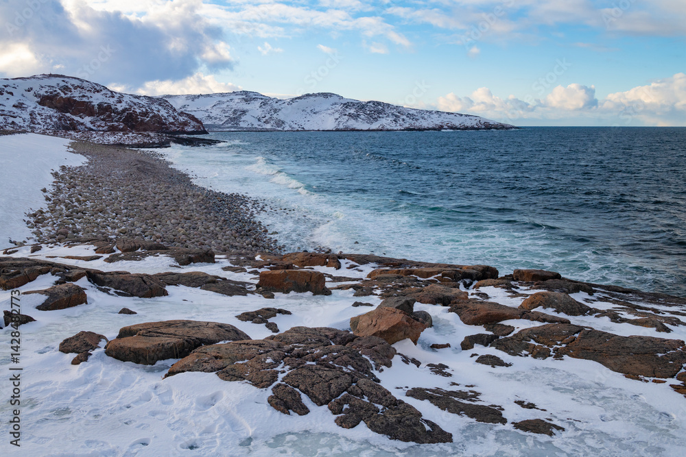 View of Dragon Egg Beach on a March evening. Barents Sea coast. Teriberka, Russia
