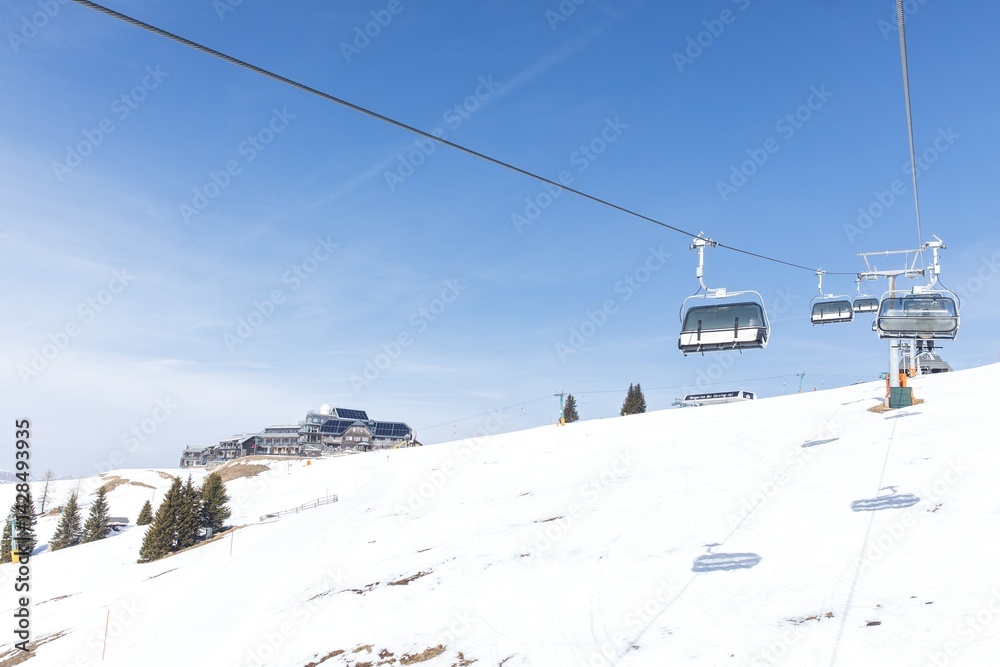 Scenic mountain view with ski lifts on snowy slope under blue sky Scenic mountain view with ski lifts on snowy slope under blue sky