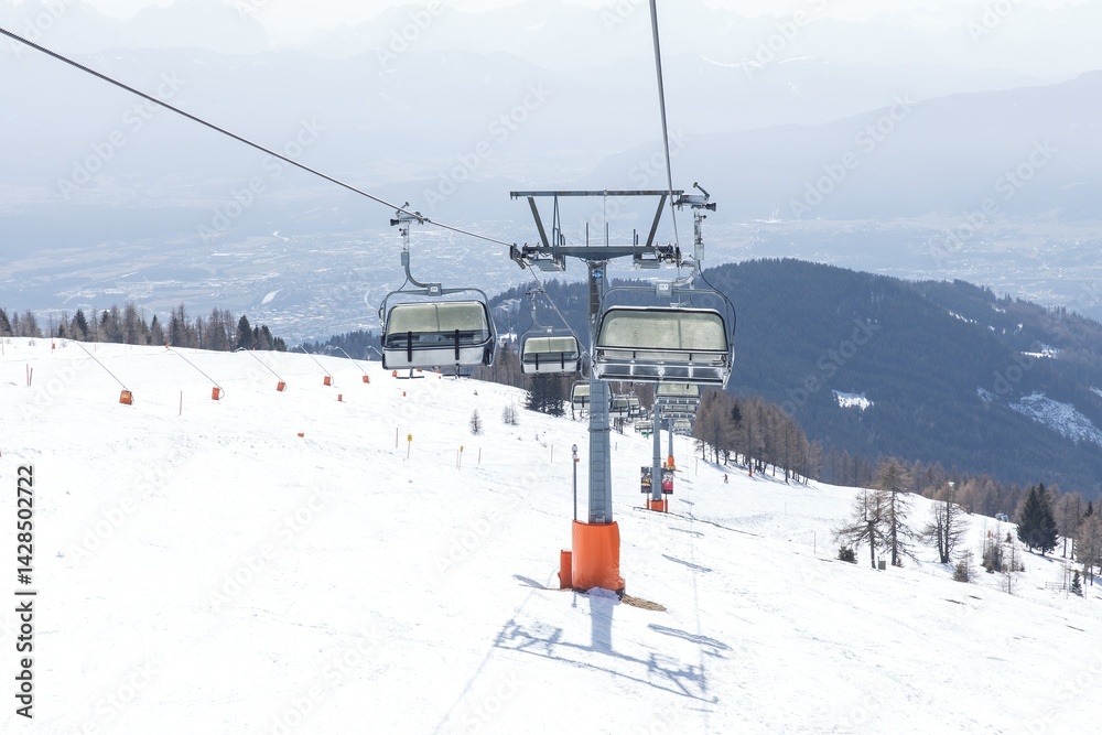 Scenic mountain ski lift over snowy slopes in remote alpine resort Scenic mountain ski lift over snowy slopes in remote alpine resort