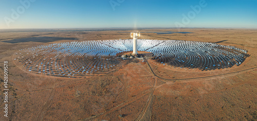 Expansive array of mirrors surround Khi Solar One concentrated solar tower in dry desert landscape of South Africa photo
