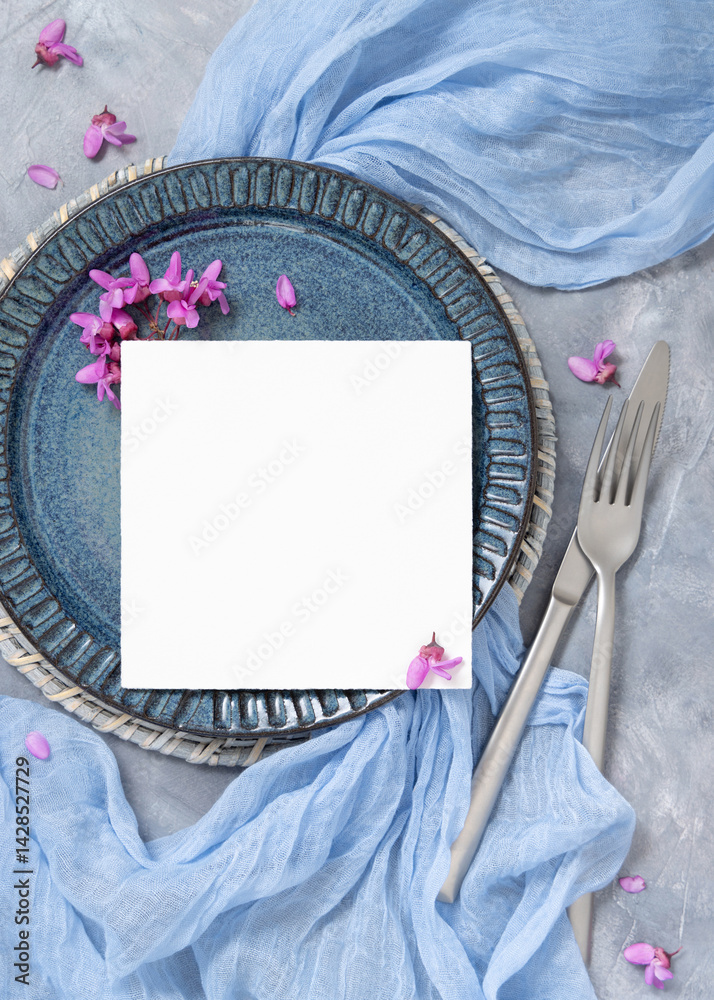 Wedding table place with a card near fabric and wild purple flowers top view on gray, spring mockup