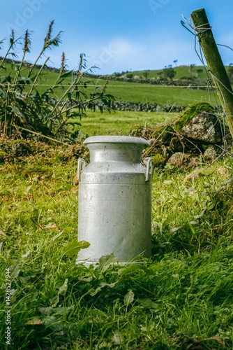 Obraz na płótnie A aluminum milk churn rests in a field of lush green grass, Vintage Milk Churn in a Lush Green Pasture Azores. Rustic Aluminum Milk Can Standing Amidst the Vibrant Countryside of Ilha de Sao Jorge w salonie