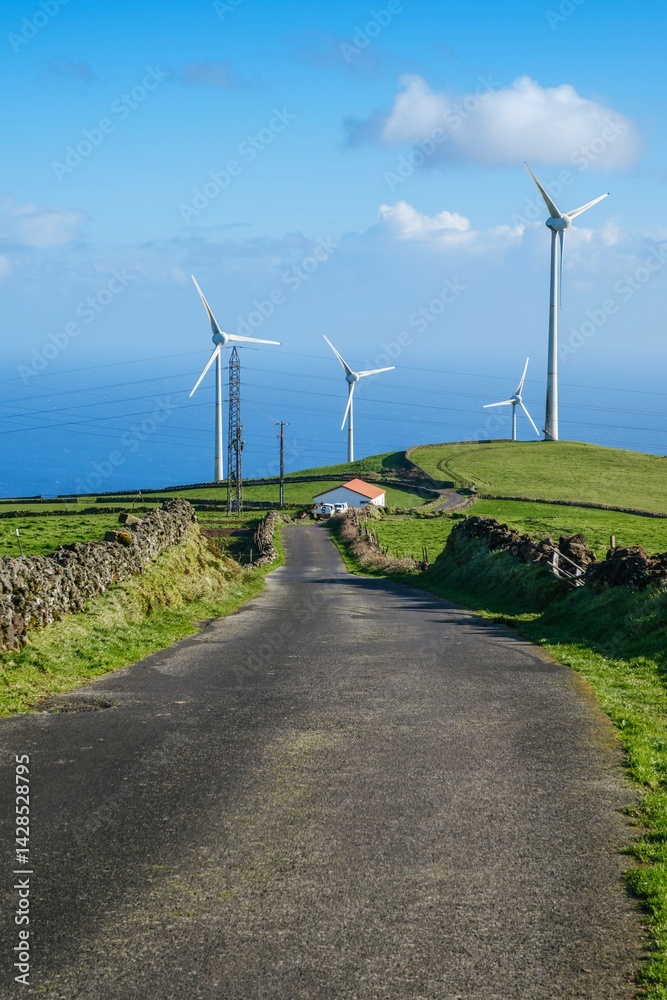 Modern wind turbines on the verdant hills of Serra do Cume with a sweeping vista of Terceira Island. The image captures the renewable energy technology with the natural beauty of the Azores landscape