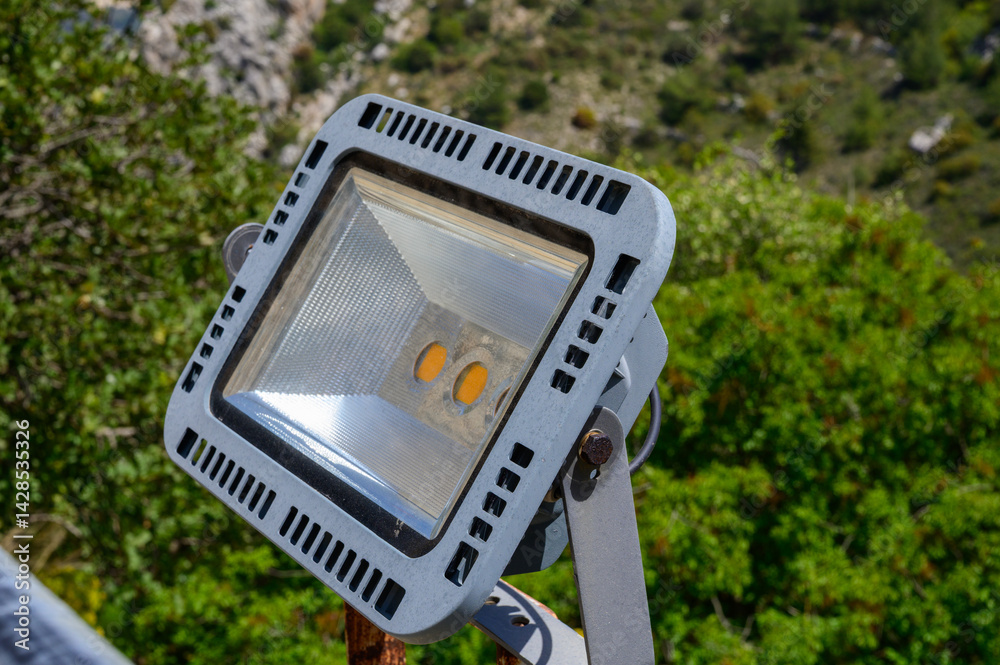 A contemporary LED spotlight installed on the ancient stone wall of St. Hilarion Castle in Northern Cyprus.