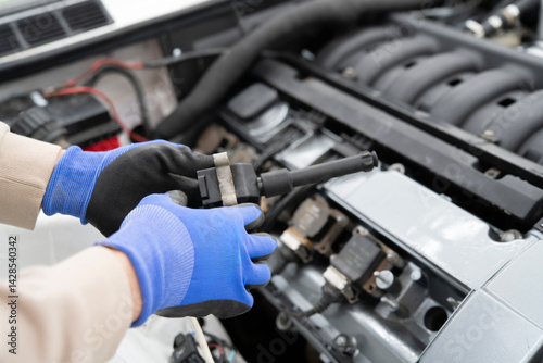 Photography Car Mechanic Working With Ignition Coil in an Automotive Garage, Focused on Engi