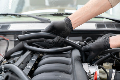 Wallpaper Mural Mechanic works on installing air hose inside the engine compartment of a vehicle, ensuring proper function at an auto repair shop. Torontodigital.ca