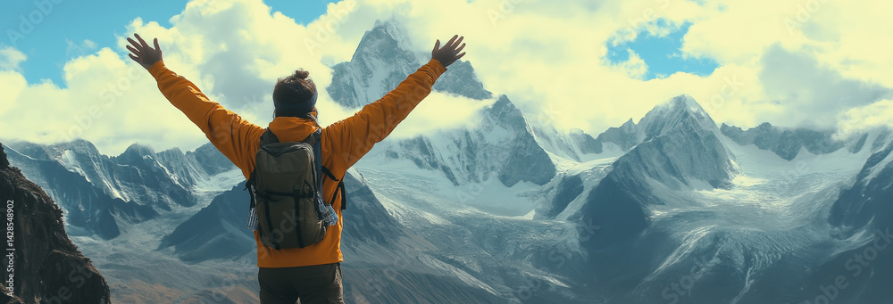 Positive man celebrating on mountain top, with arms raised up
