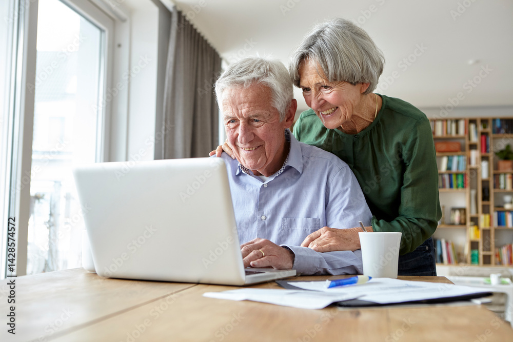 Seniors enjoying time together using a laptop at home Seniors enjoying time together using a laptop at home