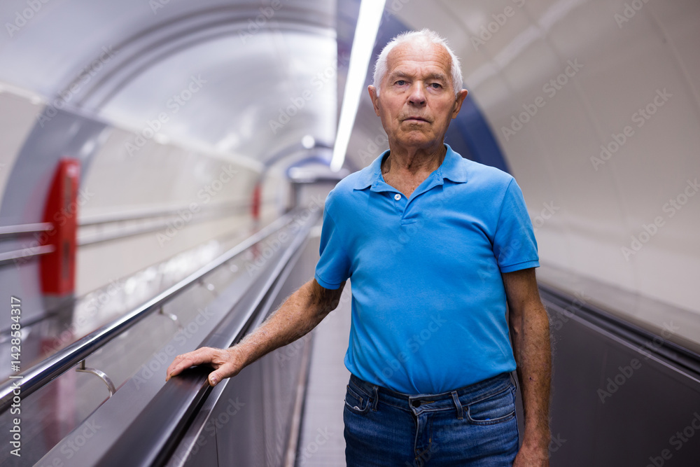 Elderly man standing on moving walkway