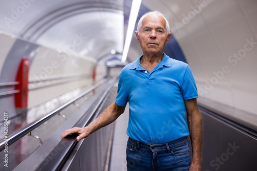 Obraz na płótnie Elderly man standing on moving walkway w salonie