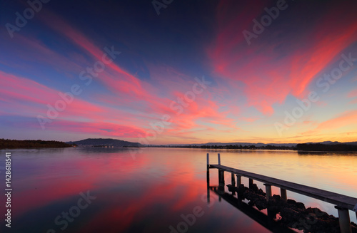 Sensational sunset across the broadwater with long jetty and reflections