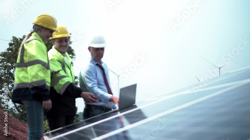 worker with orange helmet at solar panel generator solar power generator plant construction background. solar cell plant and wind generators in farm