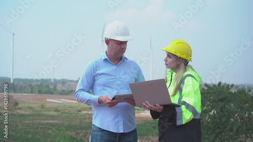 worker with orange helmet at solar panel generator solar power generator plant construction background. solar cell plant and wind generators in farm
