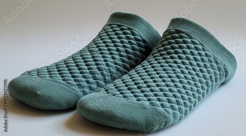 Grippy light teal yoga socks with textured bubble pattern and ribbed cuffs on plain background