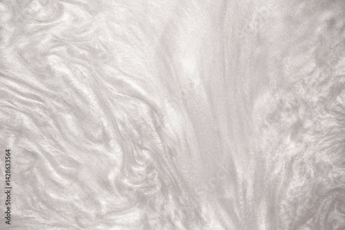 Shimmering silver abstract background. Liquid glitter paint texture waves and swirls. Beautiful shiny white glitter texture. Metallic silver paint close-up as a holiday background.