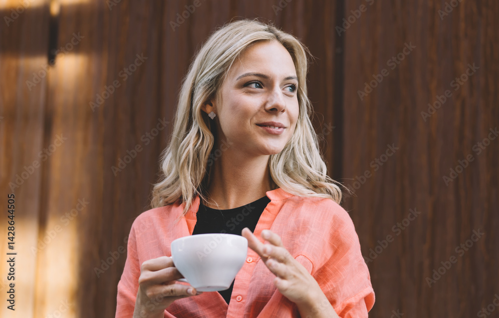 Content woman with cup of hot drink in modern workplace