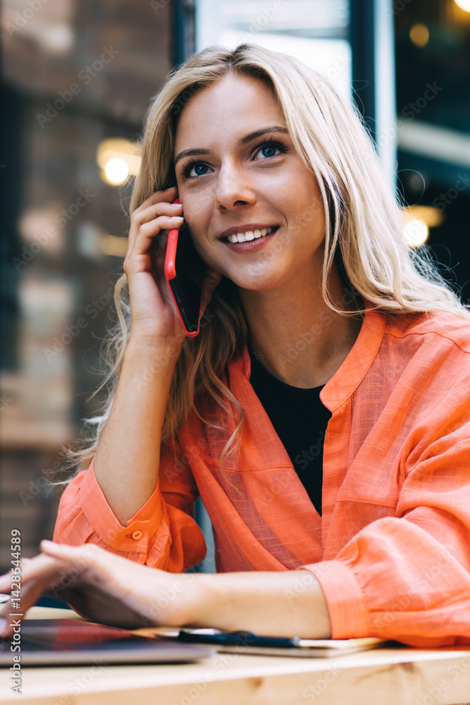 Cheerful young businesswoman working remotely in modern cafe