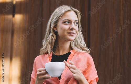 Obraz na płótnie Content woman with cup of hot drink in modern workplace w salonie