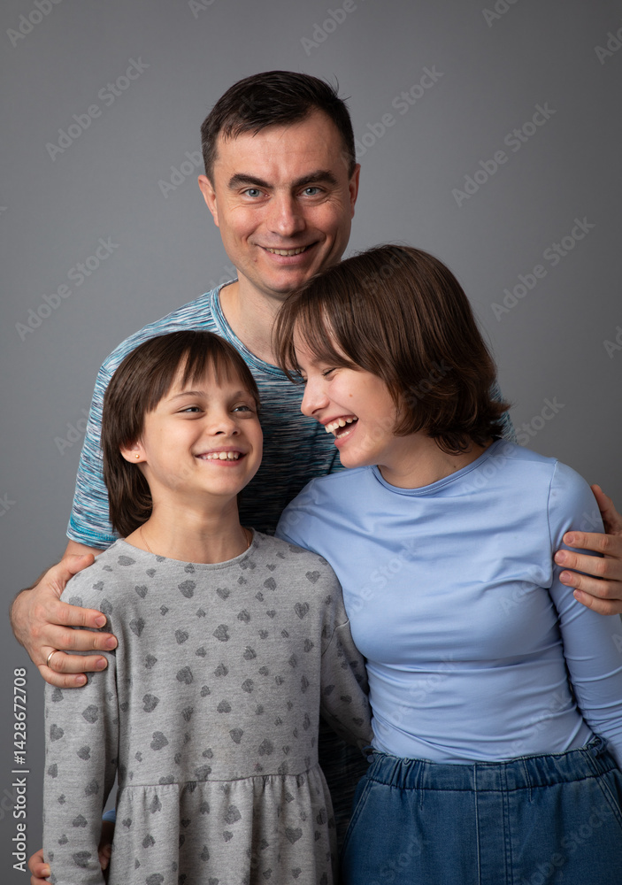 Studio portrait of family: father and daughters