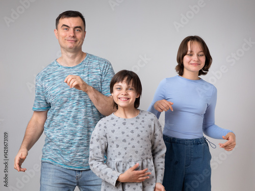 Studio portrait of family: father and daughters