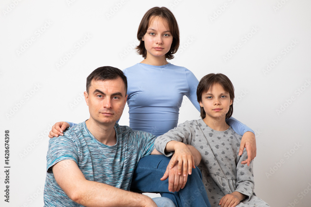 Studio portrait of family: father and daughters