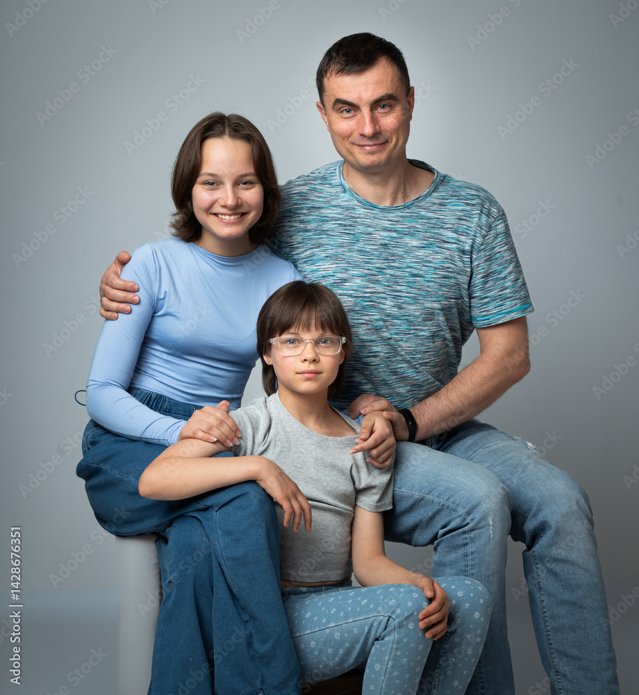 Studio portrait of family: father and daughters