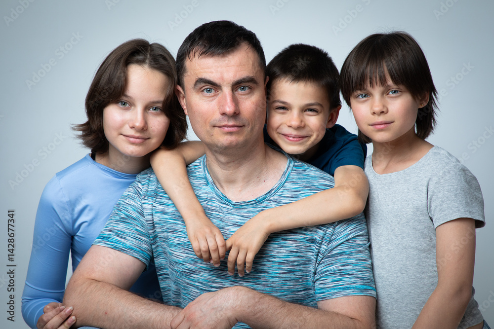 Studio portrait of family: father, son and daughters.