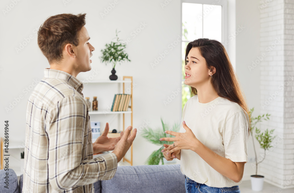 Unhappy young couple arguing at home, angry husband, wife blaming each other in life problems, conflicts in marriage, bad relationships, man and woman having quarrel, disagreement, misunderstanding
