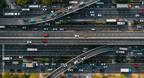 An overhead view shows a busy highway interchange with many cars and trucks moving in different directions