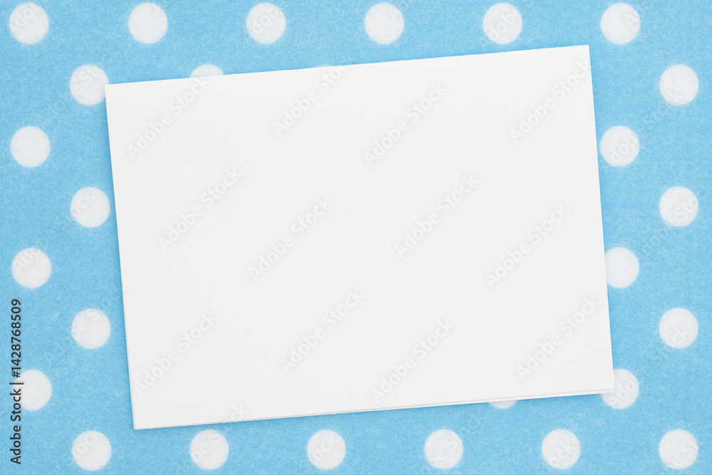 Blank greeting card on blue polka dots material