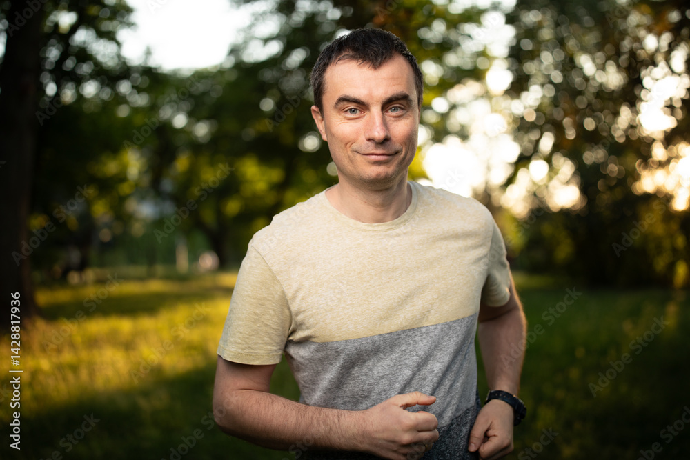Portrait of handsome man outdoors running in park in spring