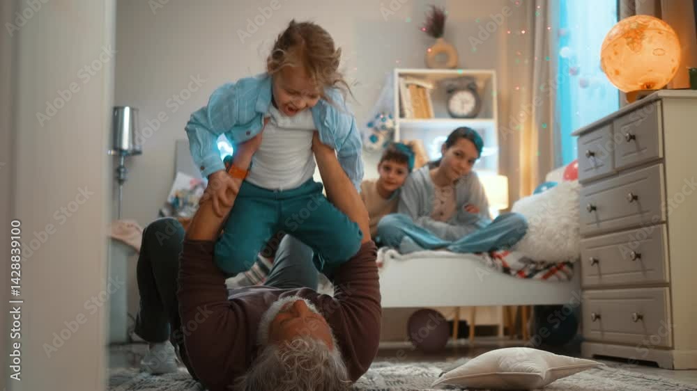Grandson and grandfather playing aiplanes together on the floor at home. Senior man holding excited little boy smiling while playing a flying game. Grandson and grandfather playing aiplanes together on the floor at home. Senior man holding excited little boy smiling while playing a flying game.